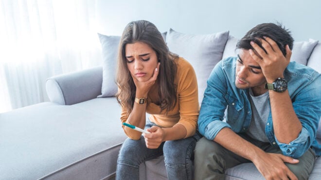couple sad looking at pregnancy test
