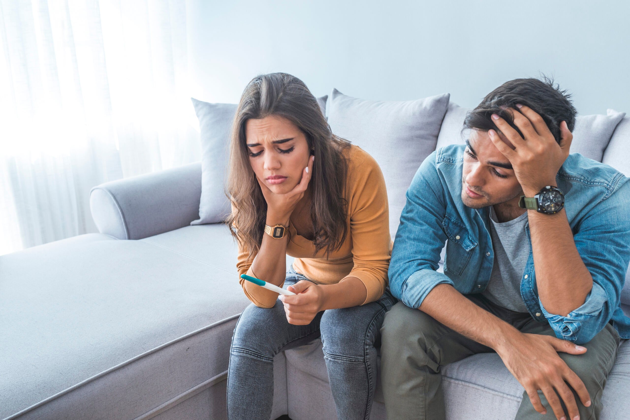 couple sad looking at pregnancy test