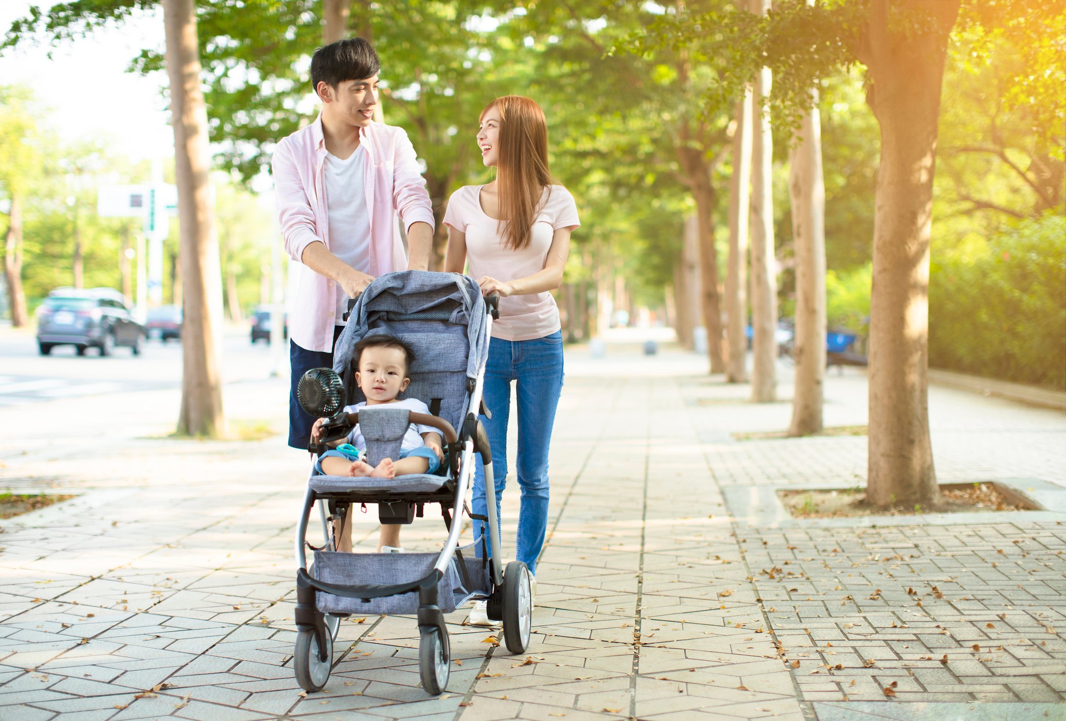 summer stroller accessories, stroller fan, happy family with baby carriage walking in the park