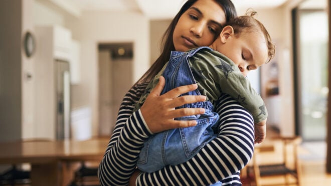 mom holding sleeping toddler