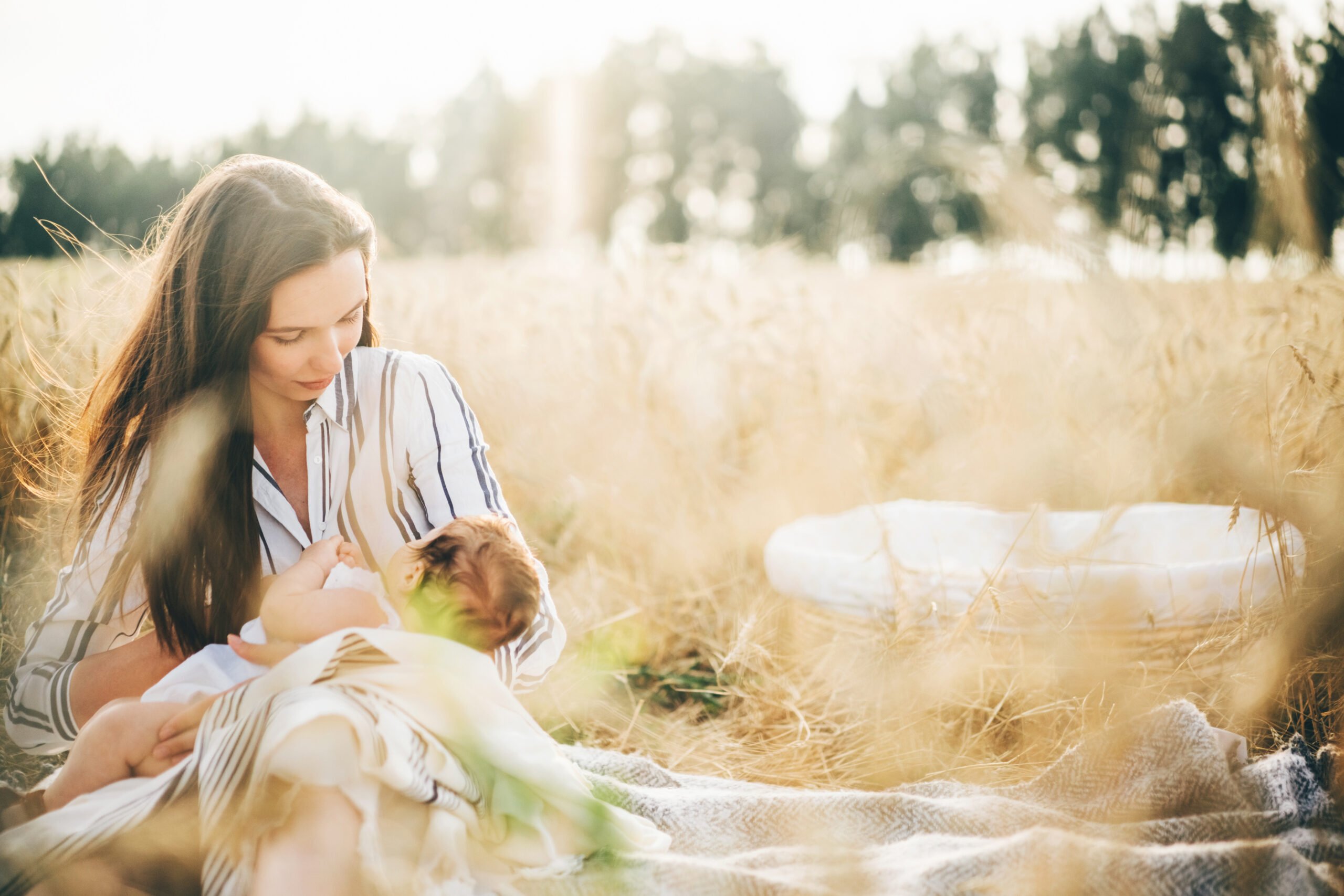 baby girl breast feeding in nature meadow