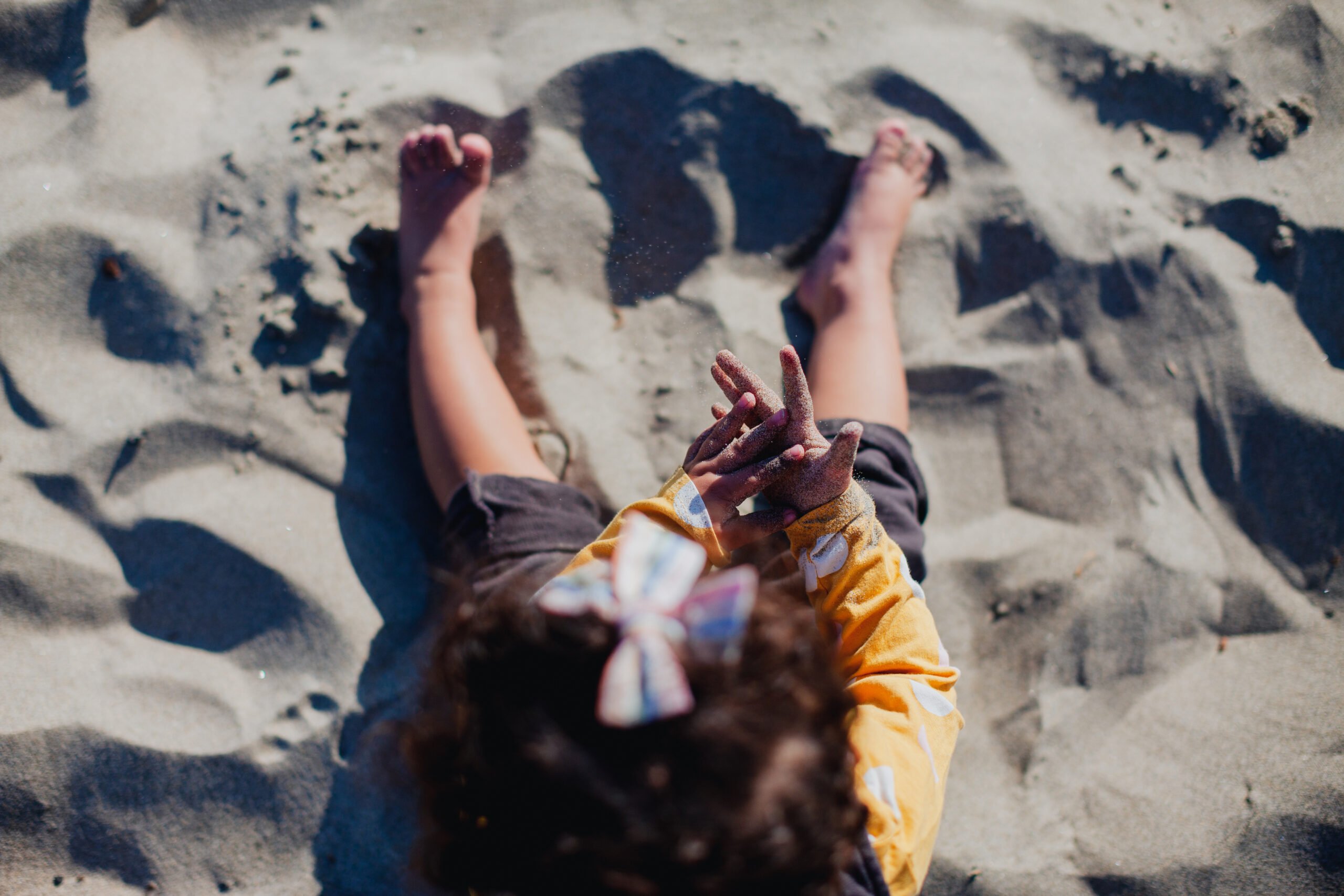 Little Girl Playing in Sand on the Beach