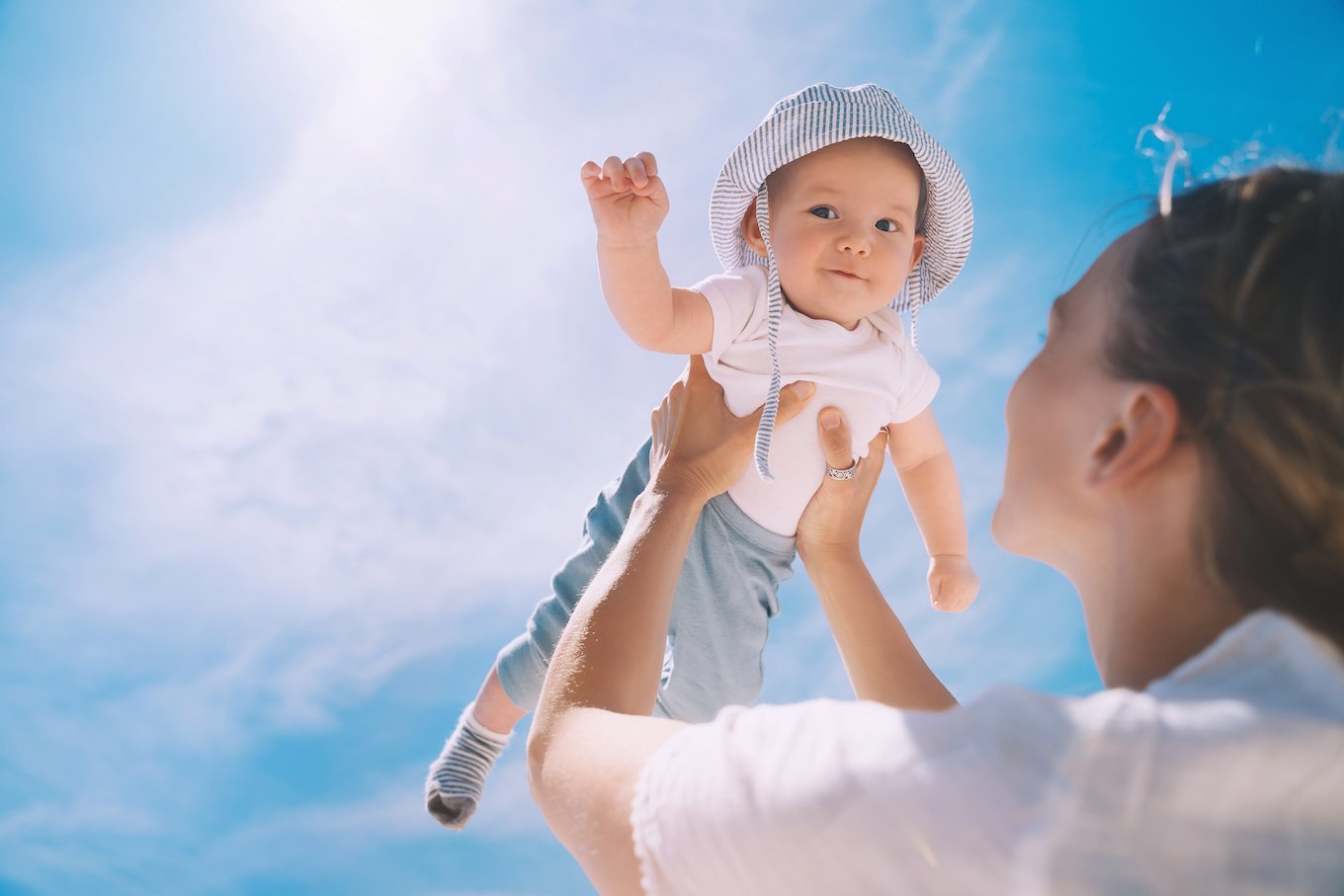 Mom holding baby towards sky