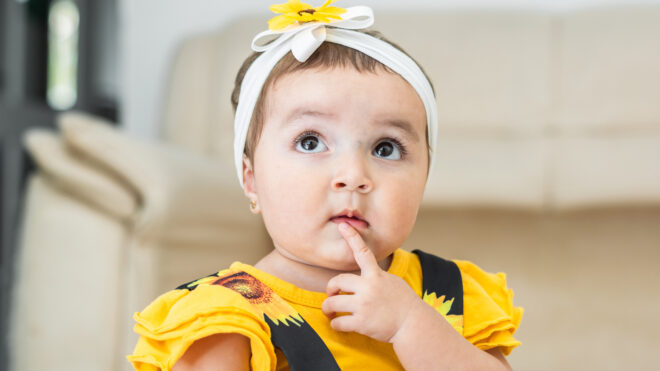 Baby girl in a yellow outfit with a headband