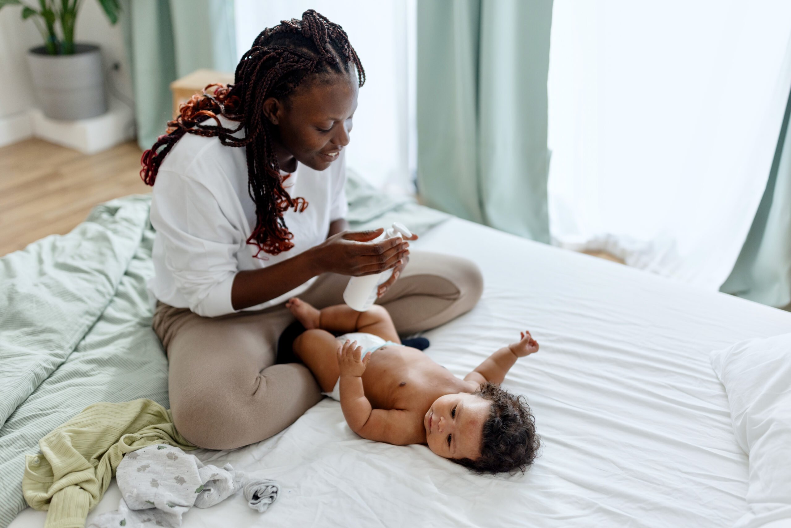 health and wellness essentials, Mother putting dy lotion on her baby boy
