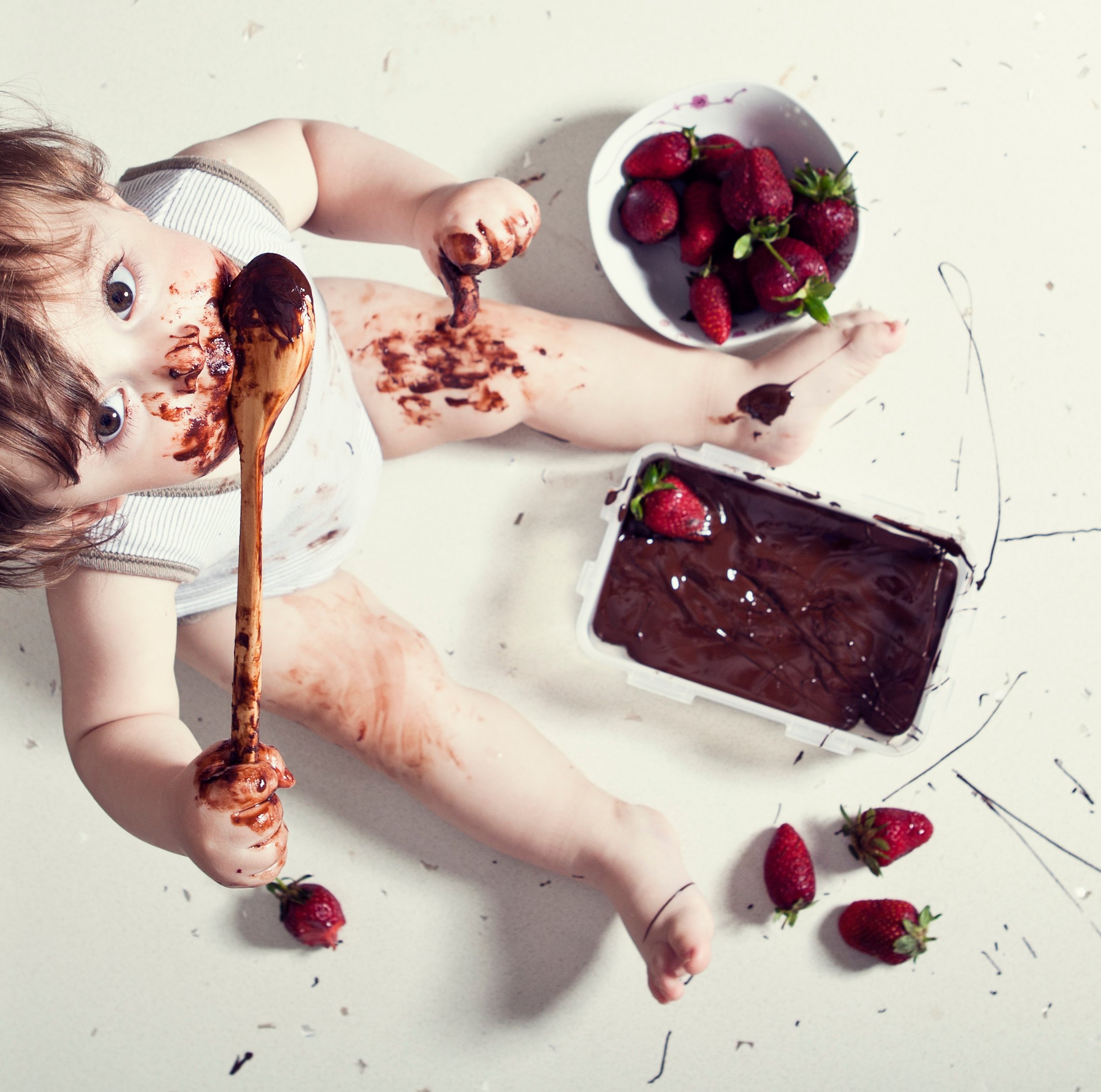 baby messily eating chocolate covered strawberries
